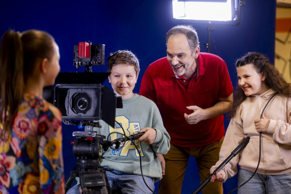 Foto von Schülern, die gemeinsam mit einem Lehrer an einem Filmprojekt an den SABEL Schulen arbeiten. Sinnbild für die angedachten Schulen am Bildungscampus Taufkirchen.